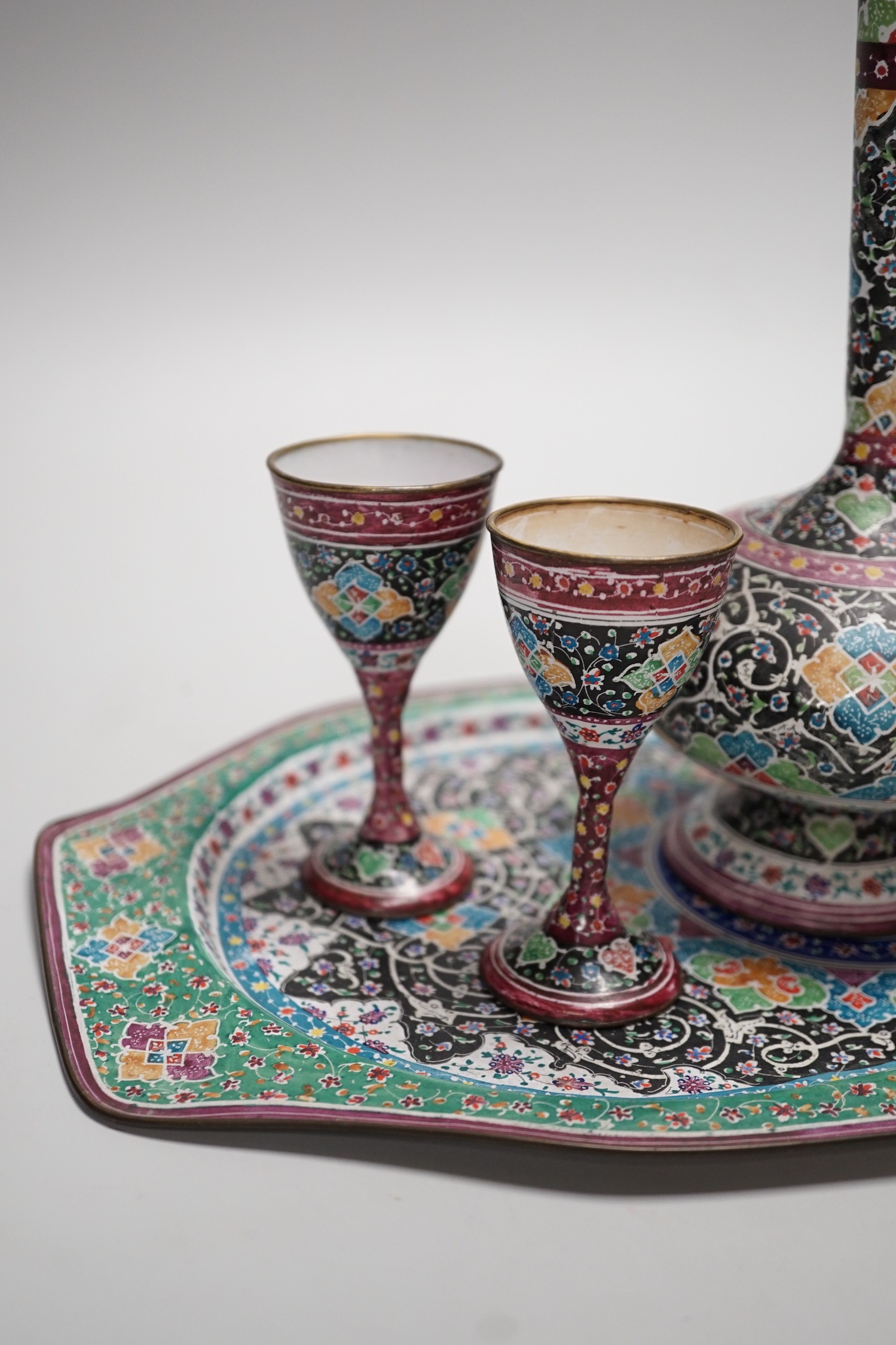 A decorative Persian enamel on copper set on stand. Tallest piece 20cm
